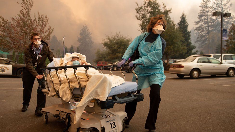 Patients are quickly evacuated from the Feather River Hospital as it burns down during the Camp fire in Paradise