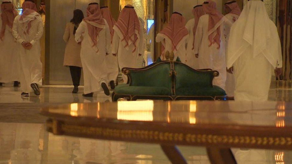 Saudi men in traditional dress are escorted through the Ritz Carlton in Riyadh.