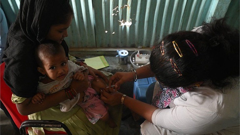 A health worker administers a vaccine to a child at a temporary vaccination camp following a measles outbreak that has caused the death of 10 children, in Mumbai on November 23, 2022.