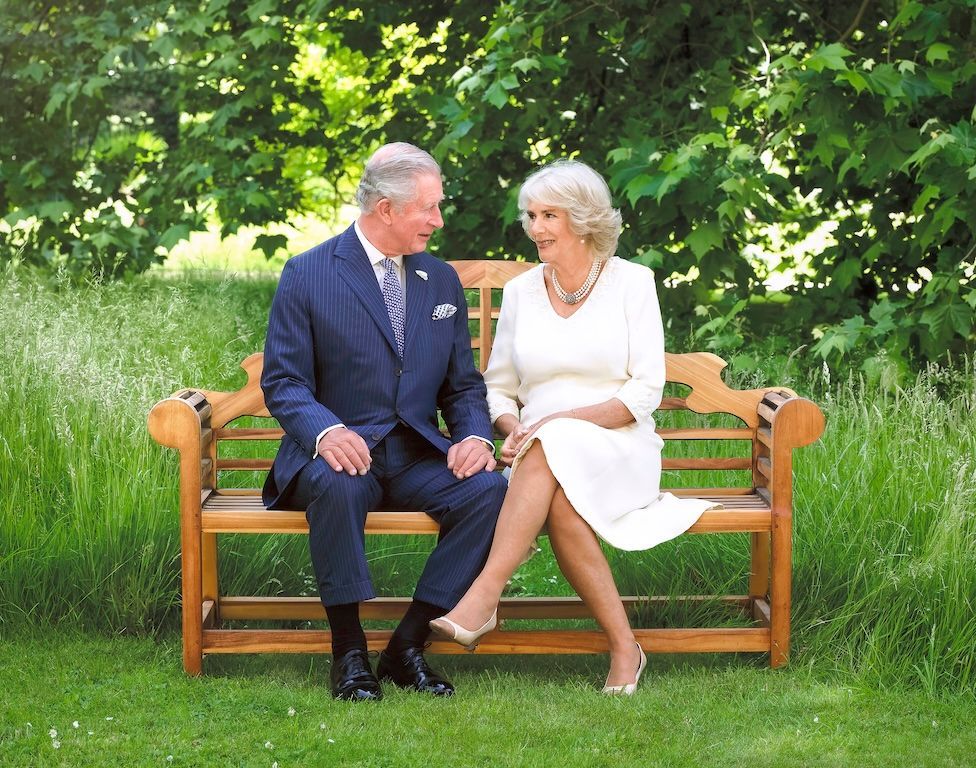King Charles III and Queen Camilla pictured in 2018, sitting on a bench