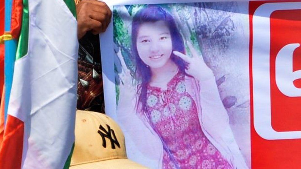 Протестующий держит плакат с изображением женщины, выступающей против переворота, Мья Тве Тве Хине