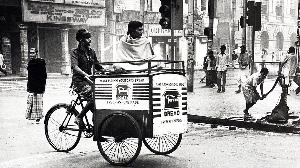 A man rides a bike through the streets of Calcutta in the 1980s