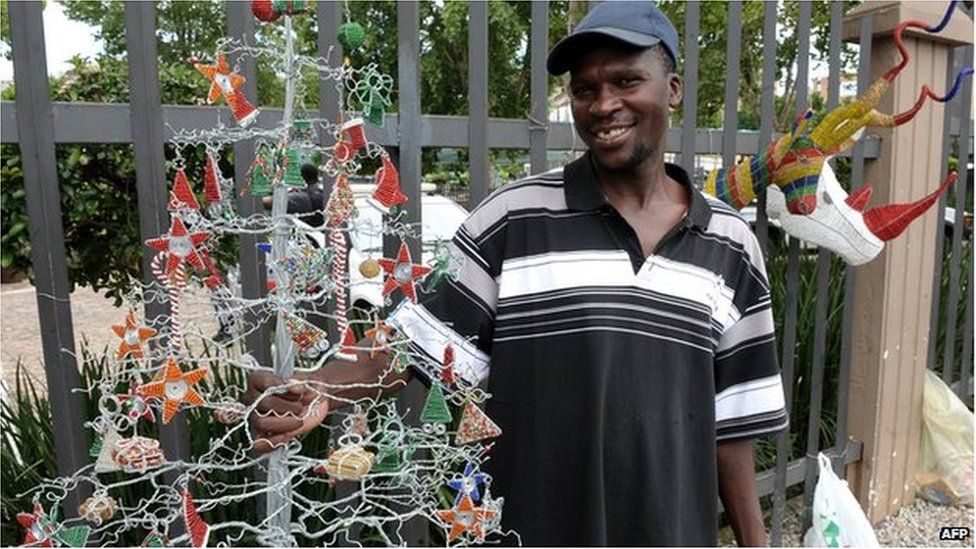 A vendor sells a hand made Christmas tree in Johannesburg, file