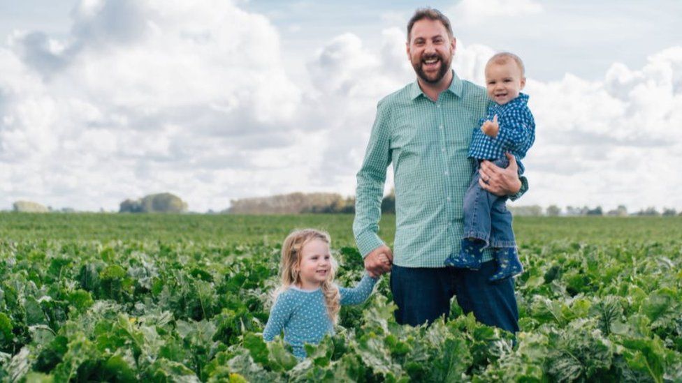 Tom Clarke and children in a field