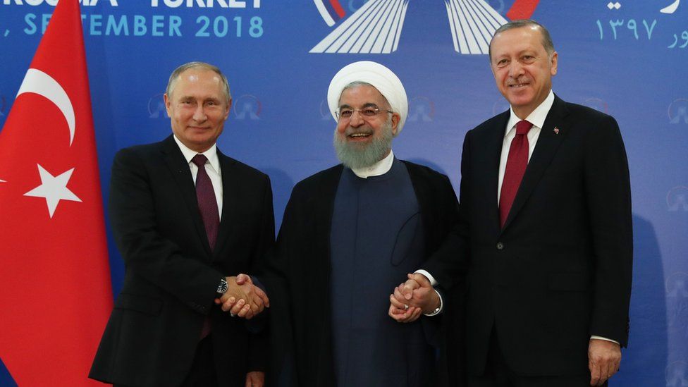 Vladimir Putin, Hassan Rouhani and Recep Tayyip Erdogan shake hands at a summit in Tehran, Iran (7 September 2018)