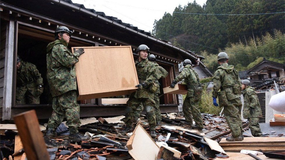 Japanese soldiers conducting a rescue operation in the debris of an earthquake in the town of Suzu