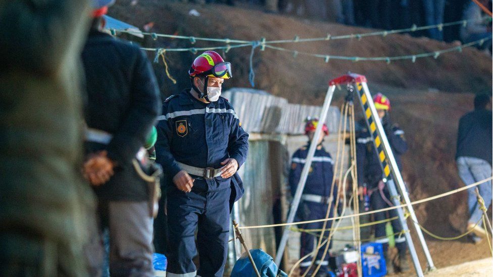 Rescuer looks into the hole