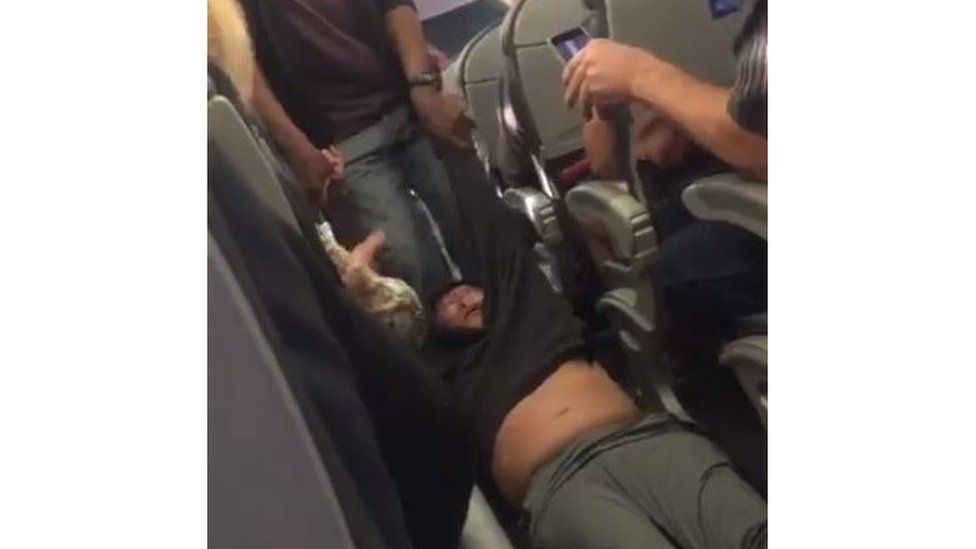 The passenger believed to be a doctor is shown in a video being dragged out of his seat by flight security