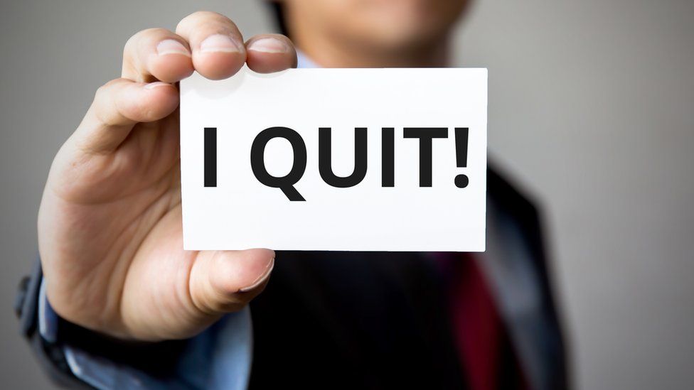 Stock image of a man holding up an 'I Quit' sign