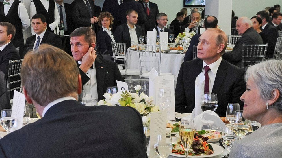 In this file photo taken on 10 December 2015, Russian President Vladimir Putin is seen centre right with retired US Lt Gen Michael Flynn, center left