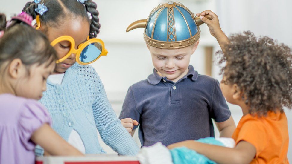 Children playing with a dressing up box