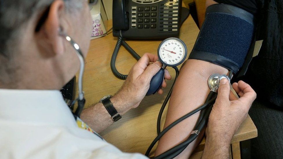 A GP checks a patient's blood pressure