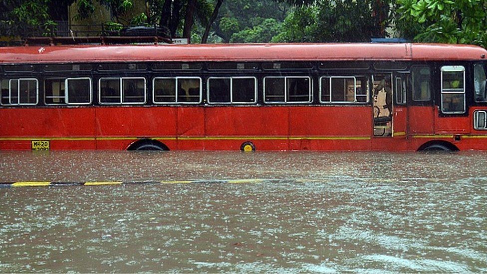 A driver looks out from inside a bus stuck in a waterlogged road during a heavy monsoon rainfall in Mumbai on June 9, 2021.