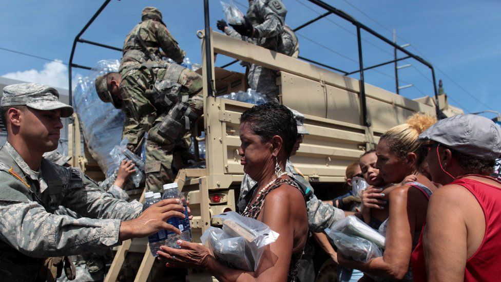 Soldiers of Puerto Rico"s national guard distribute relief items to people, after the area was hit by Hurricane Maria in San Juan, Puerto Rico September 24, 2017