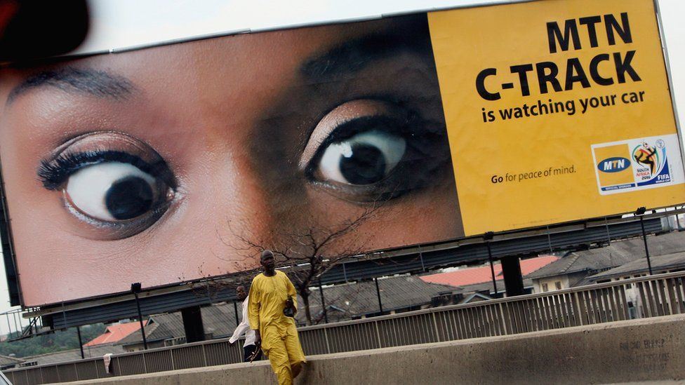 Man standing in front of an MTN billboard