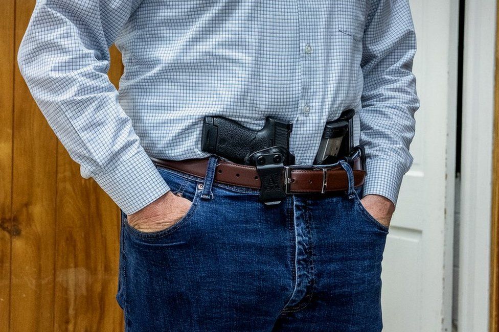 A handgun and spare magazines tucked in a waistband at a militia meeting in Virginia