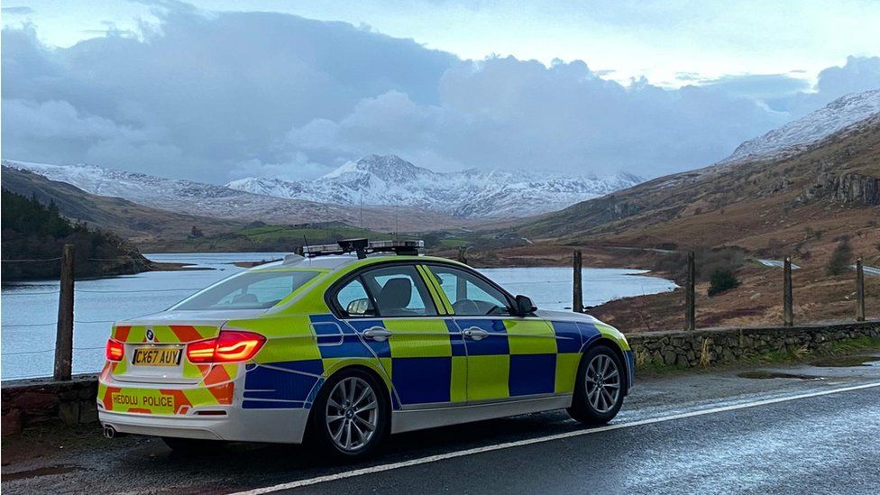 A police car with mountains in the background