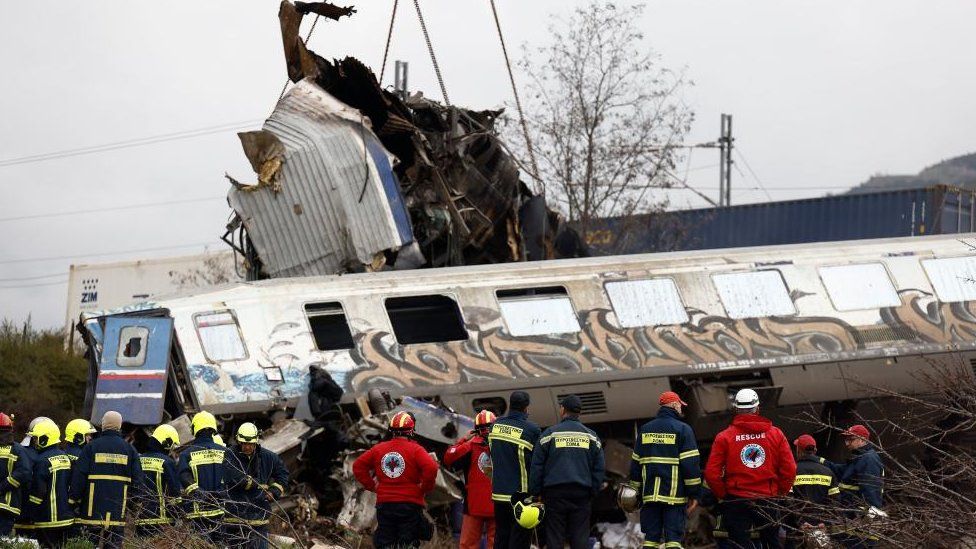 Crane vehicles try to remove pieces of damaged train wagon after a collision near Larissa city, Greece, 01 March 2023