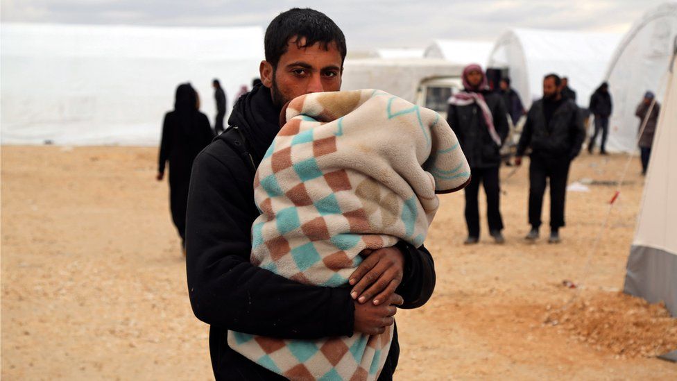 In this photo provided by Turkish Islamic aid group IHH, Syrians gather at a temporary refugee camp for displaced Syrians in northern Syria, near Bab al-Salameh border crossing with Turkey, Sunday, Feb. 7, 2016