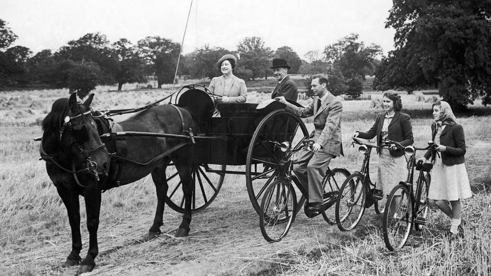 The Queen and her father on bikes alongside a horse pulling her mother in a trap