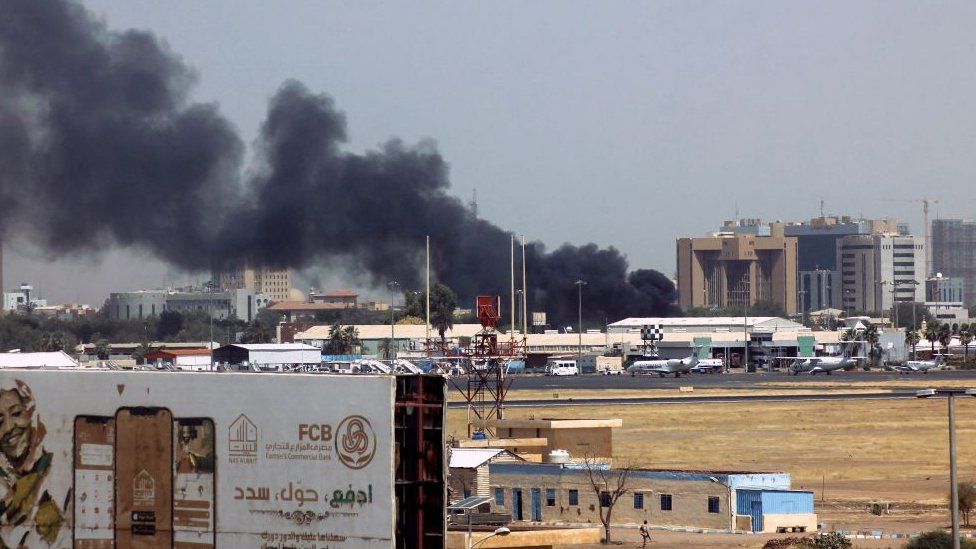 Heavy smoke billows above buildings in the vicinity of the Khartoum airport on April 15, 2023
