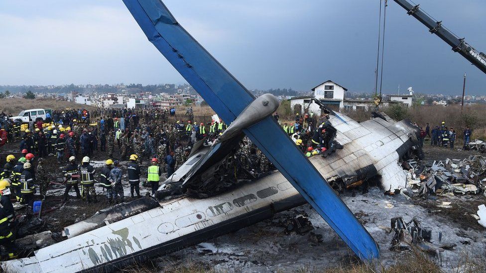 Nepali rescue workers gather around the debris of an airplane that crashed near the international airport in Kathmandu on March 12, 2018. At least 40 people were killed and 23 injured when a Bangladeshi plane crashed and burst into flames near Kathmandu airport on March 12, in the worst aviation disaster to hit Nepal in years. Officials said there were 71 people on board the US-Bangla Airlines plane from Dhaka when it crashed into a football field near the airport