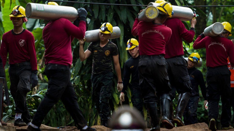 Helpers carrying oxygen tanks