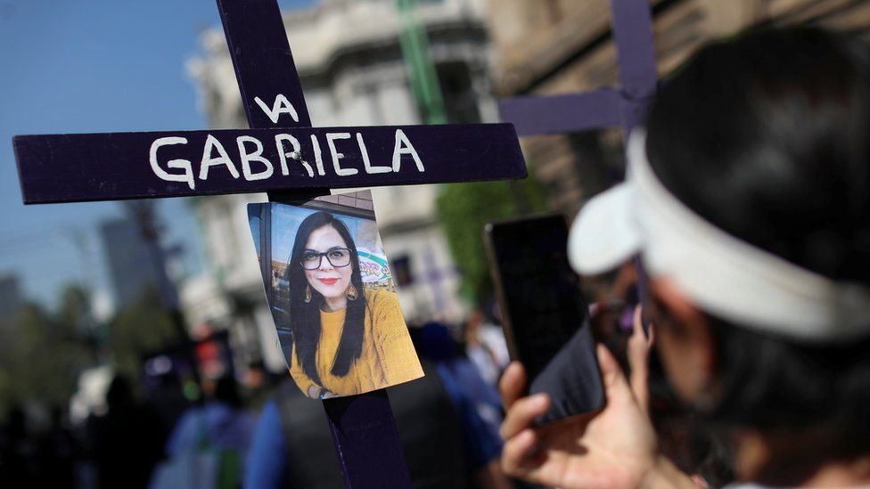 A photo is pictured on a cross as relatives and friends of victims of femicide hold a march in Mexico City