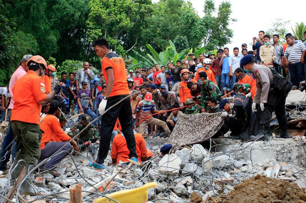 Indonesian army and the Search and Rescue Team look for survivors amongst the rubble on 7 December 2016 in Lueng Putu town, Aceh Province, Indonesia