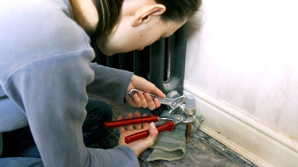 A woman repairing a central heating system