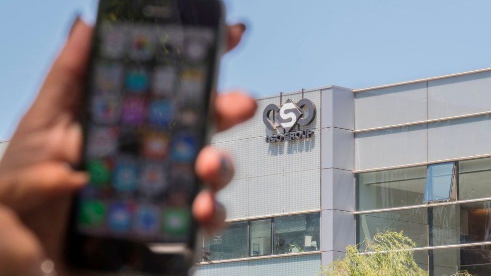 Woman uses iPhone in front of HQ of NSO group in Herzliya, Israel. File photo