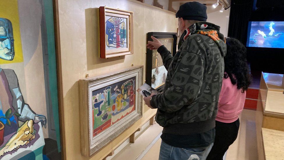Two people look at artwork