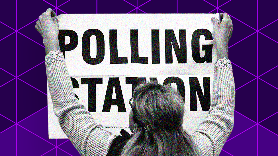 Woman hangs a polling station sign