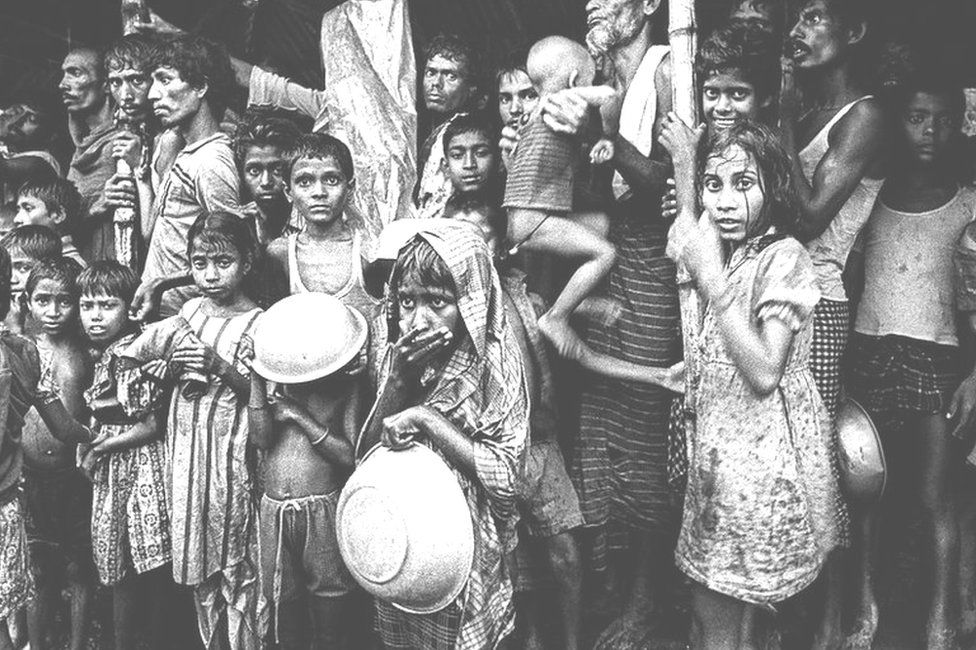 Children and adults sheltering from rain, flood victims in Mymensingh, Bangladesh. 1988.