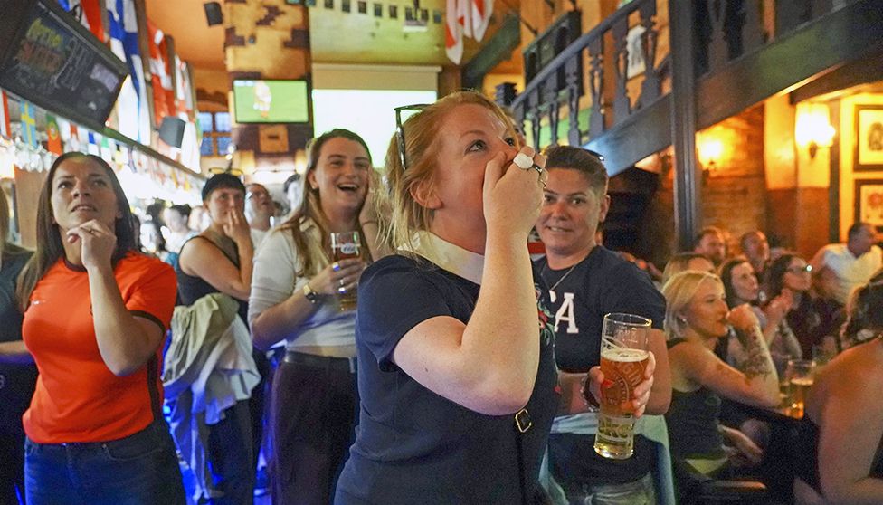 Football fans celebrate in a pub for England's fourth goal in the England v Sweden semi-final of the Women's Euros 2022