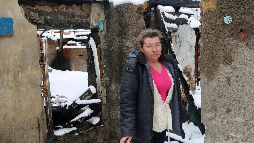 A woman outside her shell-damaged house near Donetsk, Ukraine, in March 2021