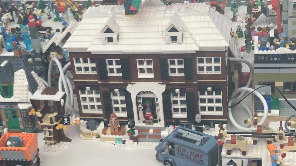 Brown two-storey house in Lego with pillars either side of the entrance door