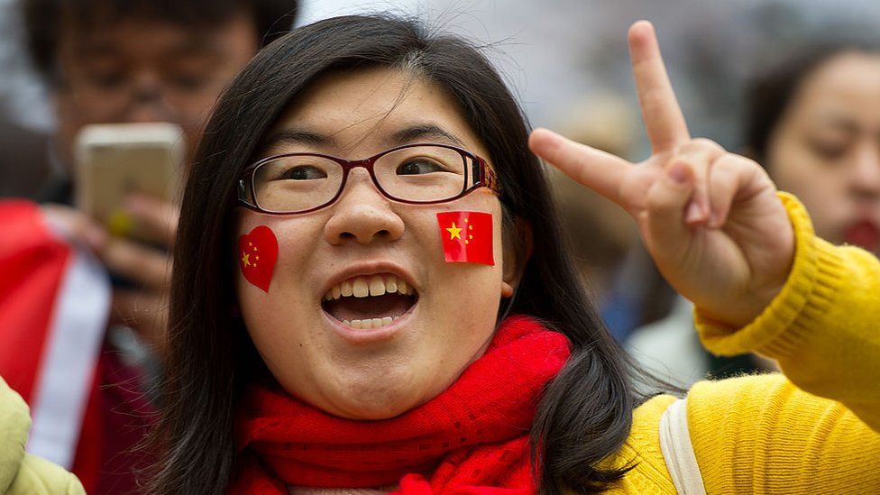 A Pro-China supporter wears stickers with the Chinese flag