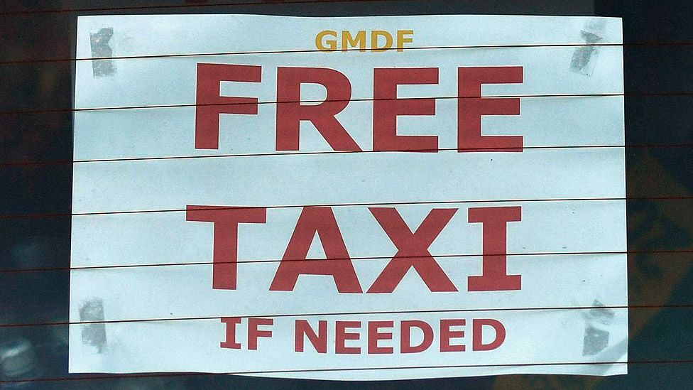 A taxi advertises its services for free in Albert Square in Manchester