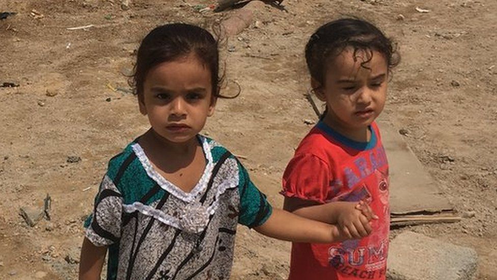 Two Iraqi children hold hands