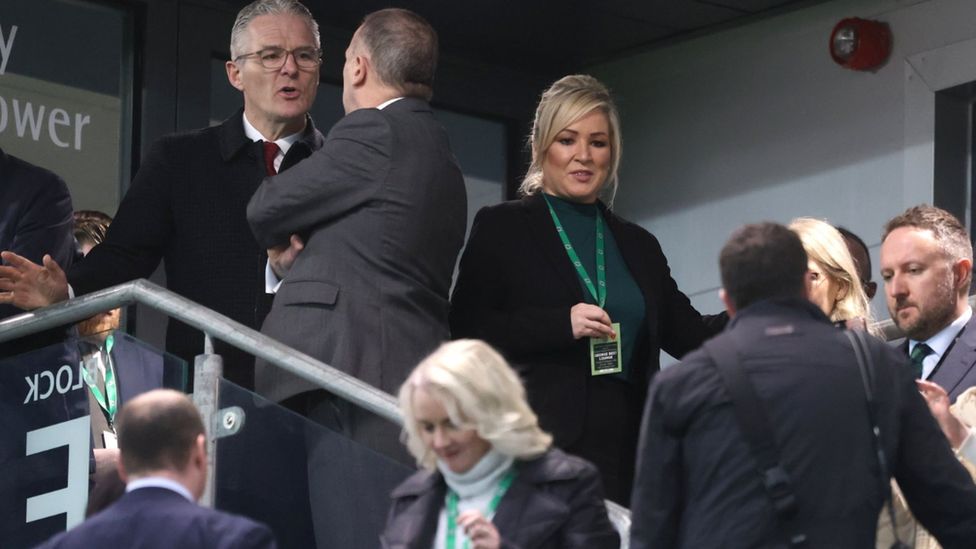 GAA President Jarlath Burns chats to IFA chief executive Patrick Nelson as Michelle O'Neill passes