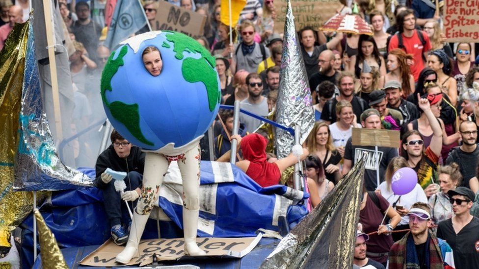 One demonstrator dresses as a globe in Hamburg