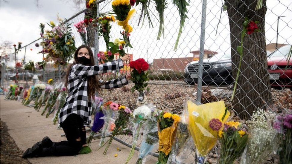 A teenage girl leaves flowers at the site of a mass shooting at King Soopers grocery store in Boulder, Colorado, U.S. March 23, 2021.