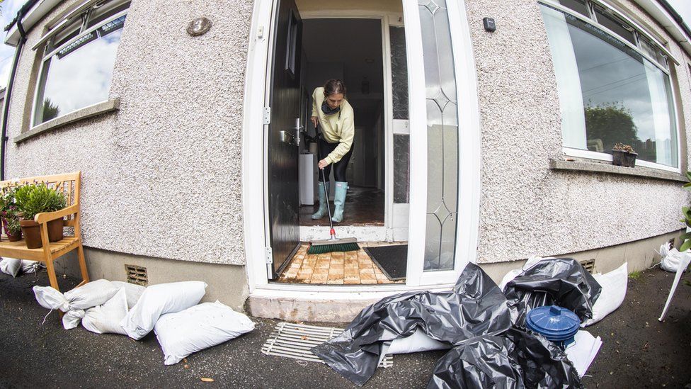 A woman cleaning her house following the flooding