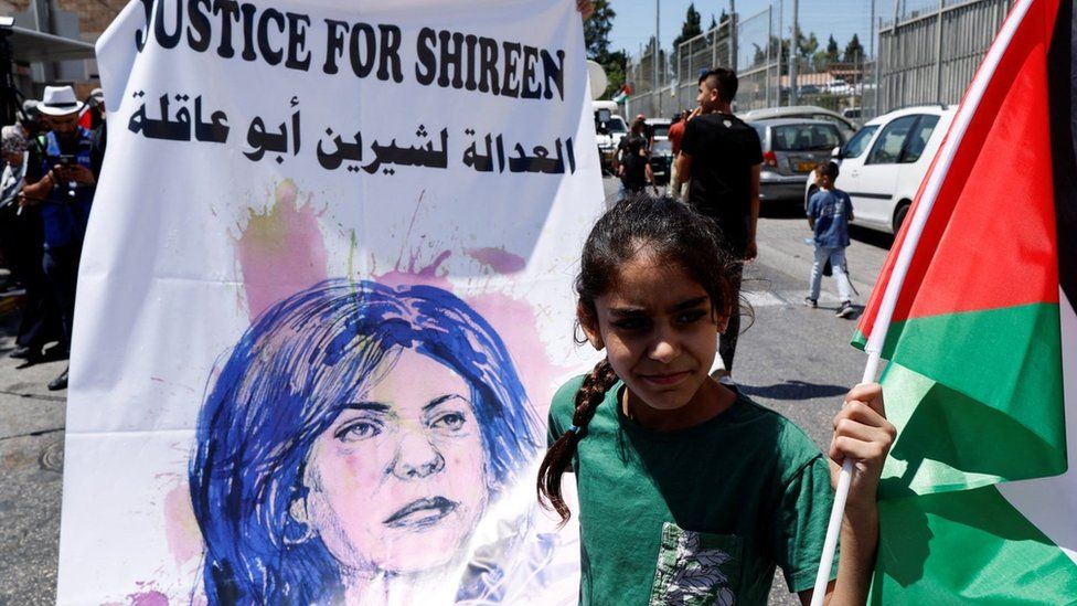 File photo showing a girl holding a Palestinian flag and a banner saying "Justice for Shireen" in Jerusalem on 15 July 2022