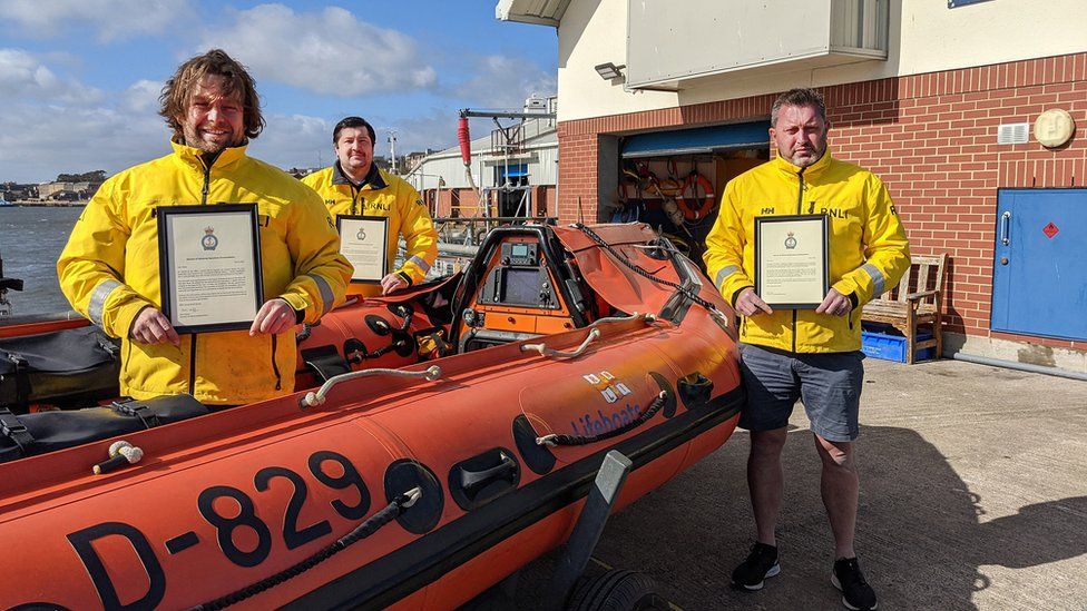 The three crew men with their certificates