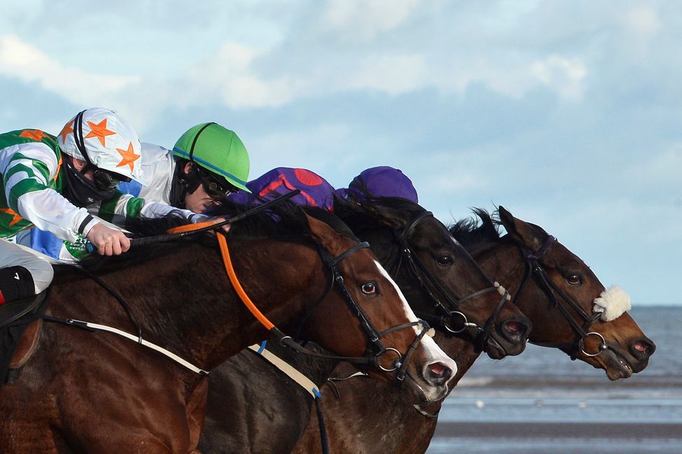 Declan McDonogh, Mark Enright and Dylan Browne McMonagle compete on the beach during the annual one-day Laytown races in Ireland, on 1 November 2021