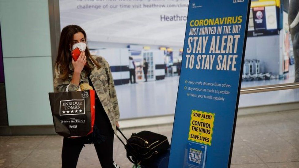A passenger wears a mask in London's Heathrow Airport