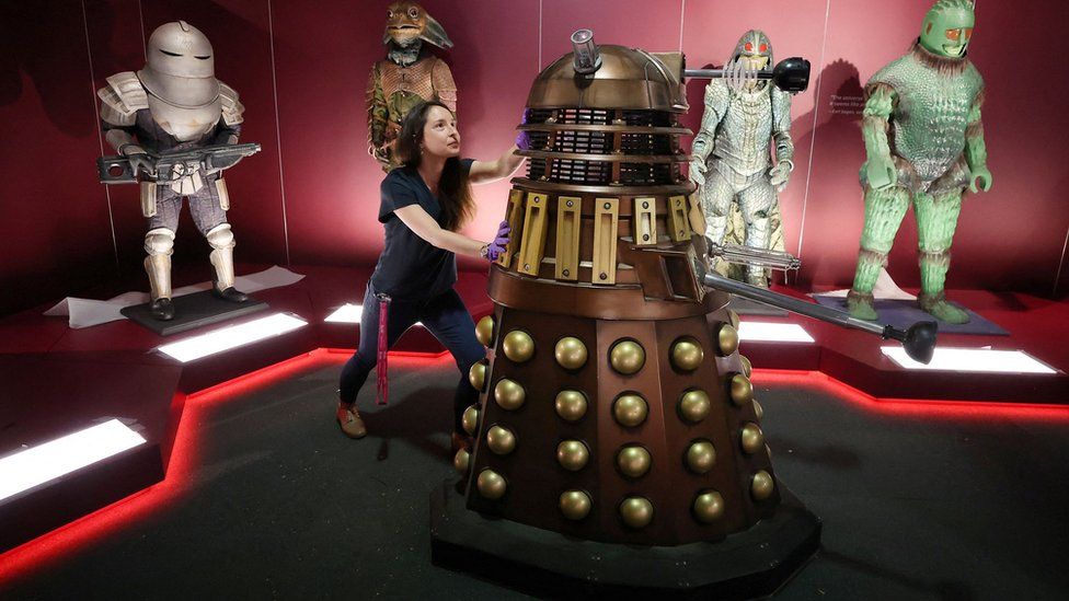 Head of museum exhibitions Catherine Johnson moves a replica of a Dalek in an exhibition