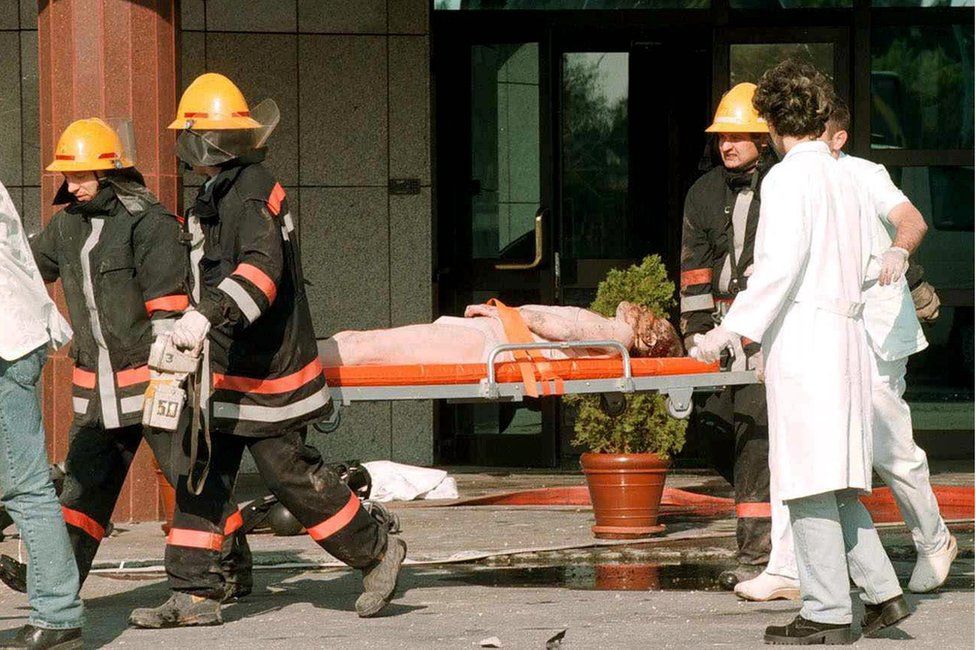 Unidentified injured Chinese embassy staff is carried away on a stretcher by Yugoslav rescue workers after the fire at the Chinese embassy, early Saturday, 08 May 1999,